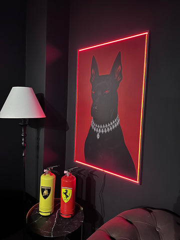 Framed artwork of a dog with neon lighting on a dark wall, next to two fire extinguishers.